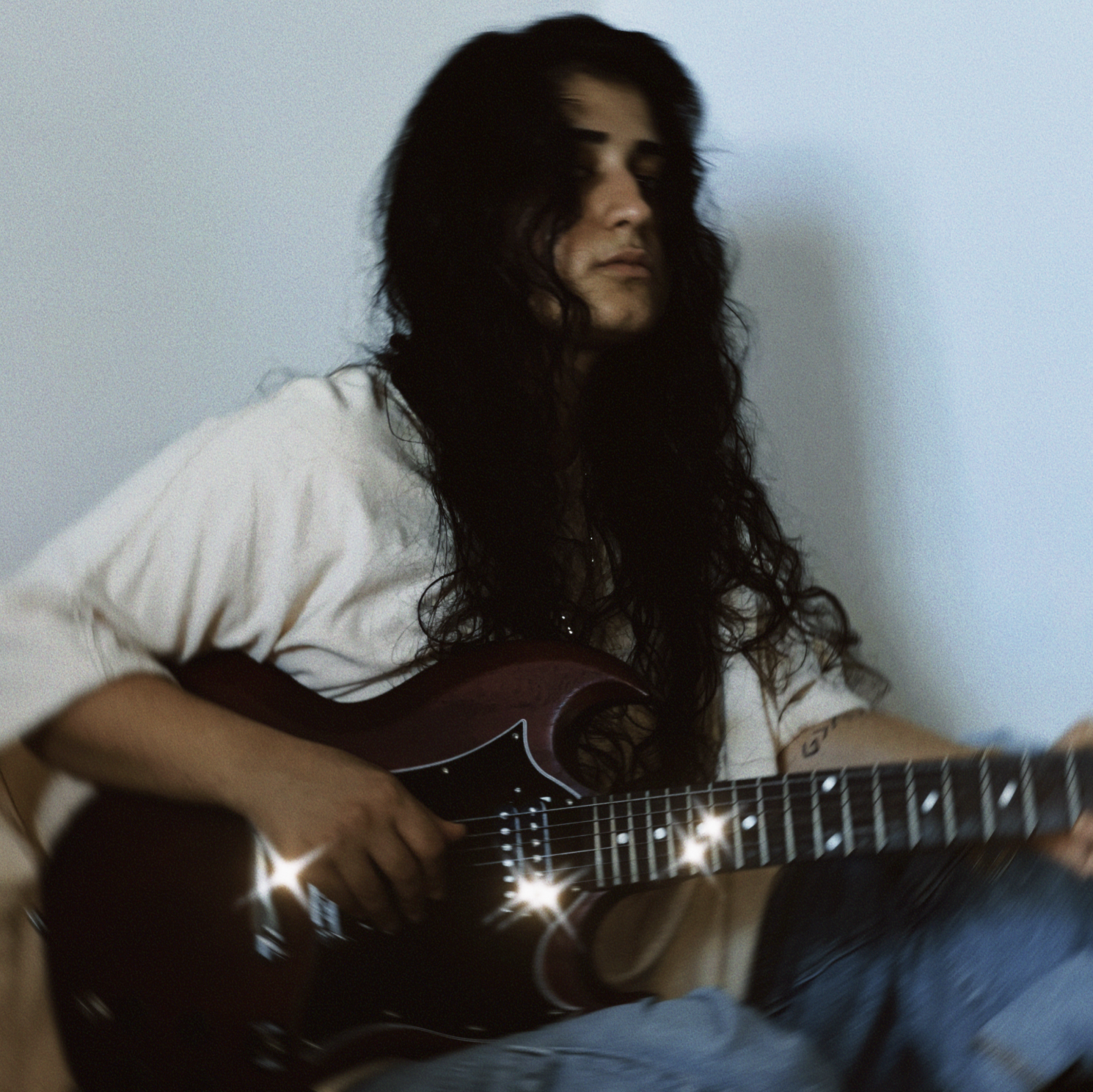 ANLIL posed on the ground wearing outfit from Urban Outfitters, holding her Gibson SG Electric Guitar