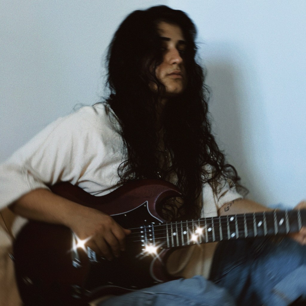 7. Editorial-style portrait of ANLIL staring into the lens, black chain choker and tousled hair echoing her Middle Eastern roots and Western grit.